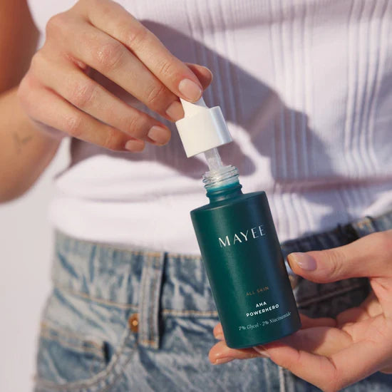 Model houdt MAYEE AHA Powerhero vast, milde chemische exfoliant voor een egale huid