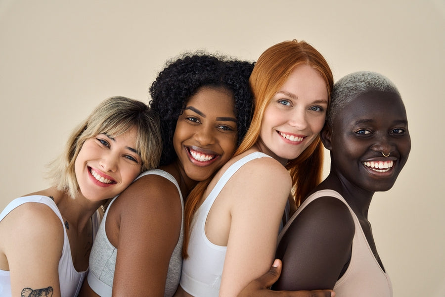 Vier lachende vrouwen met verschillende huidtinten